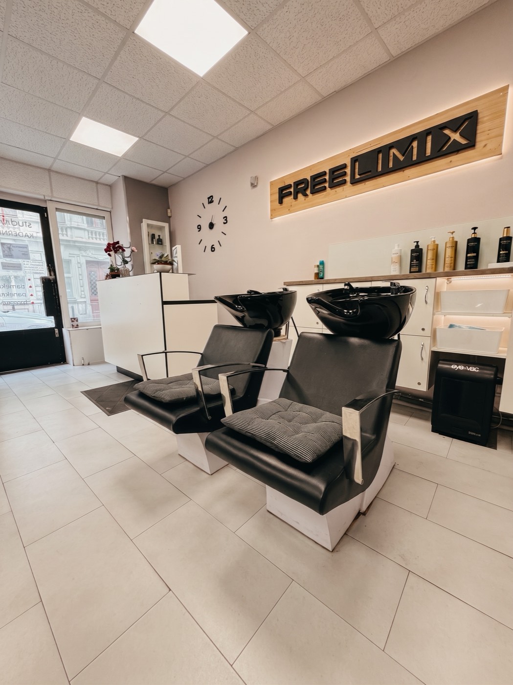 Mycí boxy v kadeřnictví pod dřevěným nápisem FreeLimix