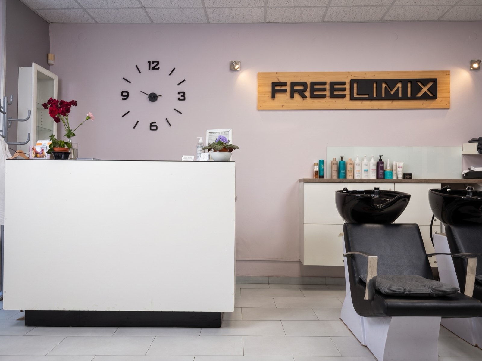 Recepce Studia Itta s nástěnnými hodinami, nápisem FreeLimix a mycími boxy