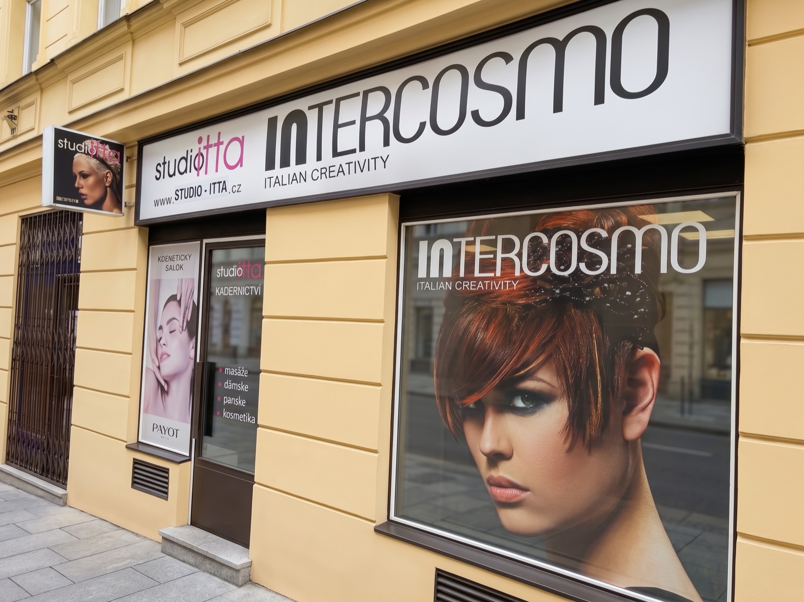 Výloha Studia Itta ve Smečkách 28 s nápisem studio itta a logem Intercosmo